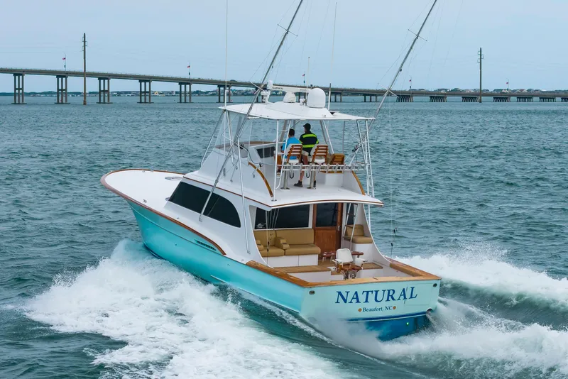 Slide: The Image of Custom Carolina Scarborough 56 Convertible yacht cruising near a bridge, 1993 model. - 43