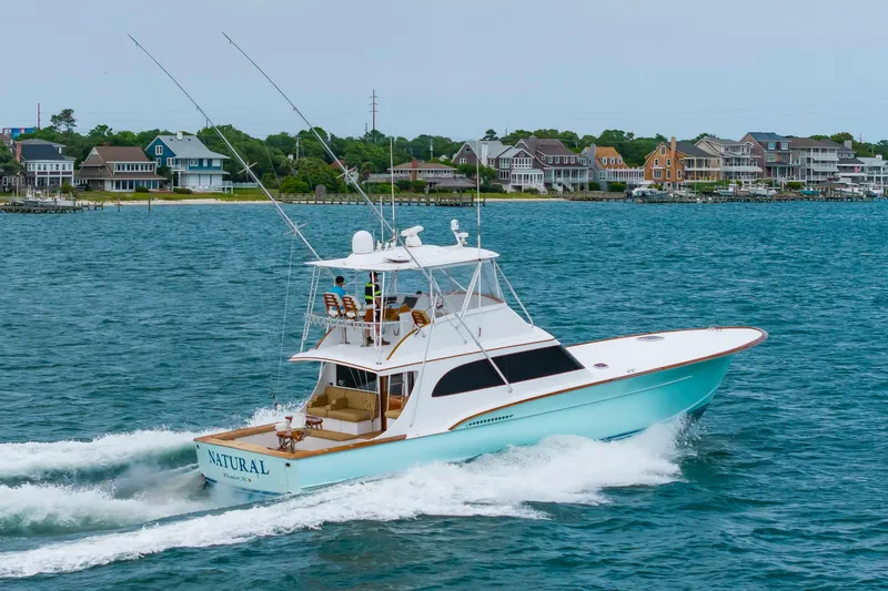 Slide: The Image of Custom Carolina Scarborough 56 Convertible yacht cruising near coastal homes, 1993 model. - 45