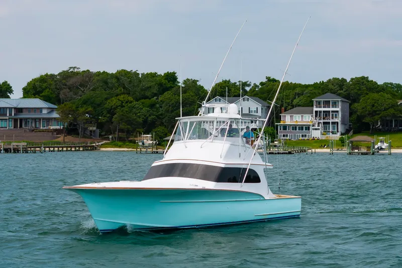 Slide: The Image of Custom Carolina Scarborough 56 Convertible yacht cruising near waterfront homes, 1993 model. - 54