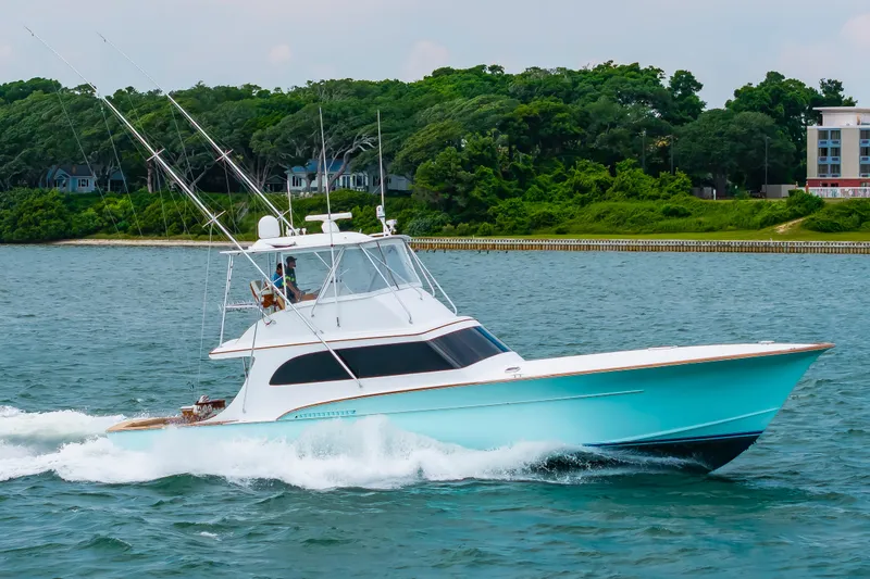 Slide: The Image of Custom Carolina Scarborough 56 Convertible yacht cruising on water, 1993 model, with lush greenery backdrop. - 56