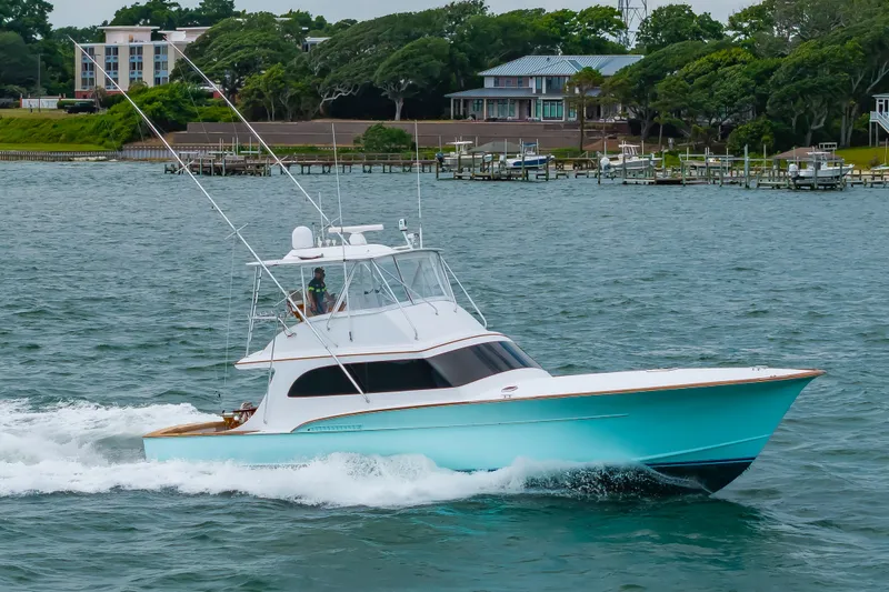 Slide: The Image of 1993 Custom Carolina Scarborough 56 Convertible yacht cruising on a scenic waterway. - 60