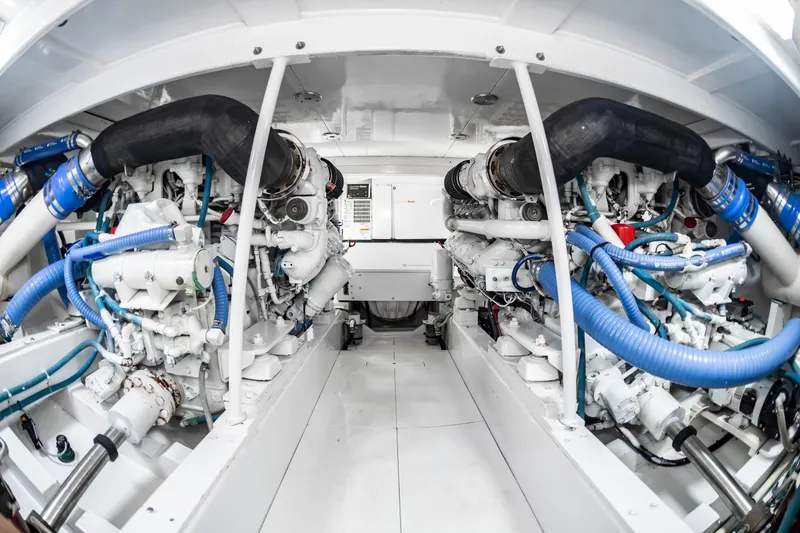 Slide: The Image of Engine room of 1993 Custom Carolina Scarborough 56 Convertible yacht, showcasing dual engines and piping. - 65