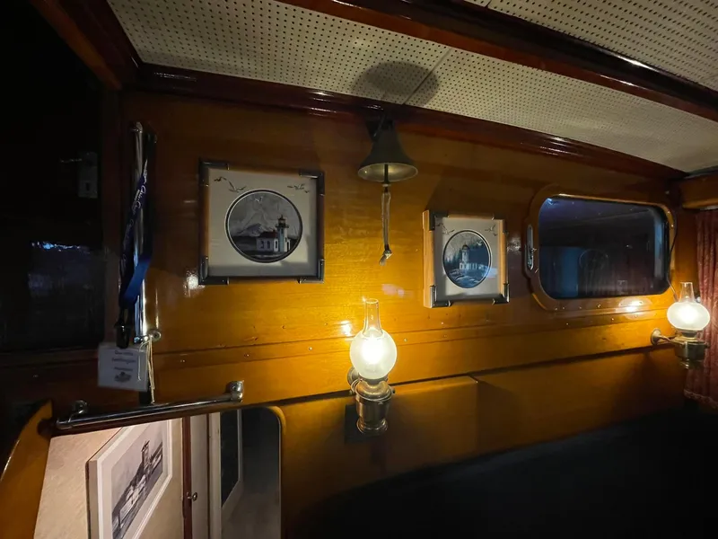 Slide: The Image of 1951 Chris-Craft Catalina interior with framed pictures, vintage lamps, and wooden paneling. - 12
