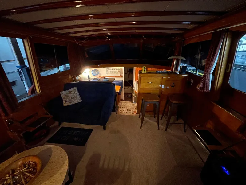 Slide: The Image of Interior of a 1951 Chris-Craft Catalina boat with cozy seating and wooden decor. - 24