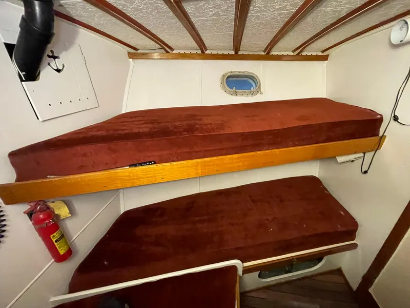 Slide: The Image of 1951 Chris-Craft Catalina cabin with red bunk beds and a small porthole window. - 34