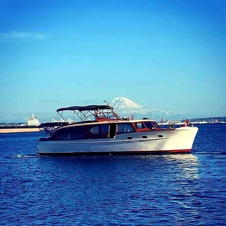 Slide: The Image of 1951 Chris-Craft Catalina boat on blue water with mountain backdrop. - 37