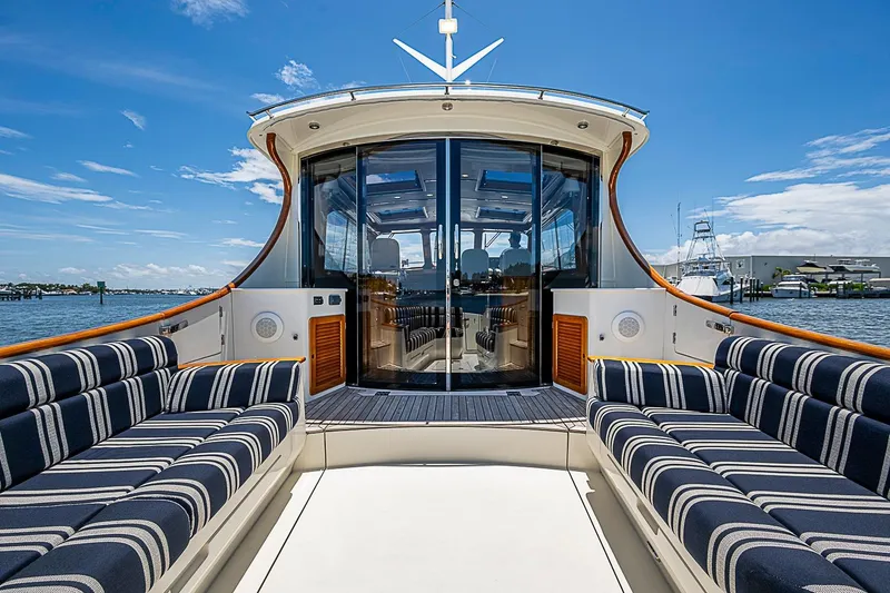 Slide: The Image of Luxurious 2015 Hinckley Talaria 48 yacht with striped seating, docked under a clear blue sky. - 10