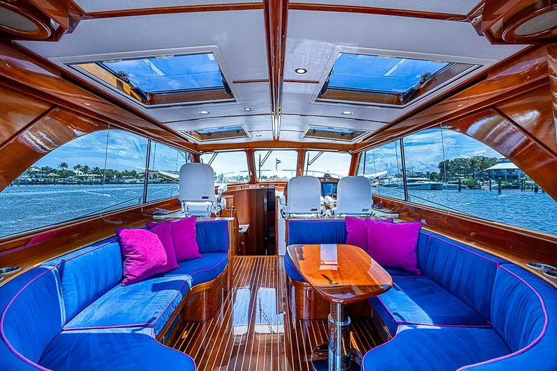 Slide: The Image of Luxurious 2015 Hinckley Talaria 48 yacht interior with blue seating and vibrant pink cushions. - 11
