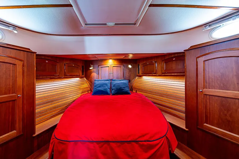 Slide: The Image of Luxurious 2015 Hinckley Talaria 48 yacht cabin with red bedding and wooden interior. - 22