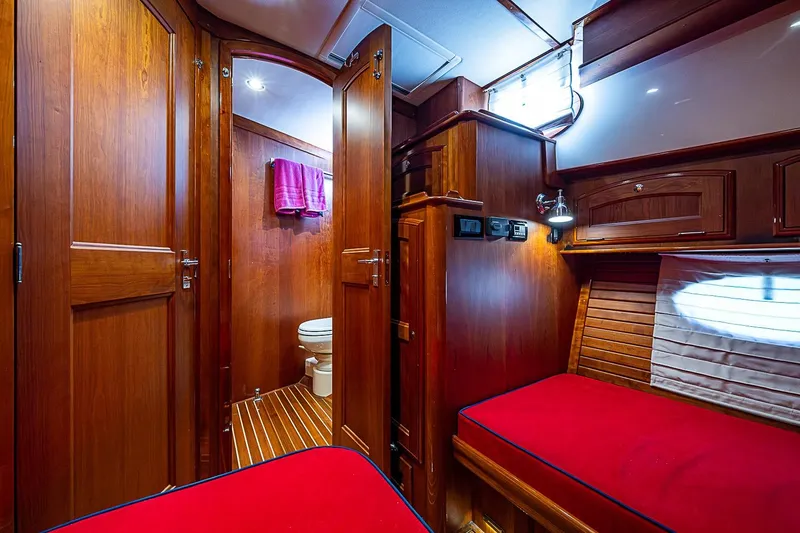 Slide: The Image of Luxurious 2015 Hinckley Talaria 48 yacht interior with wooden finish and cozy red bedding. - 25