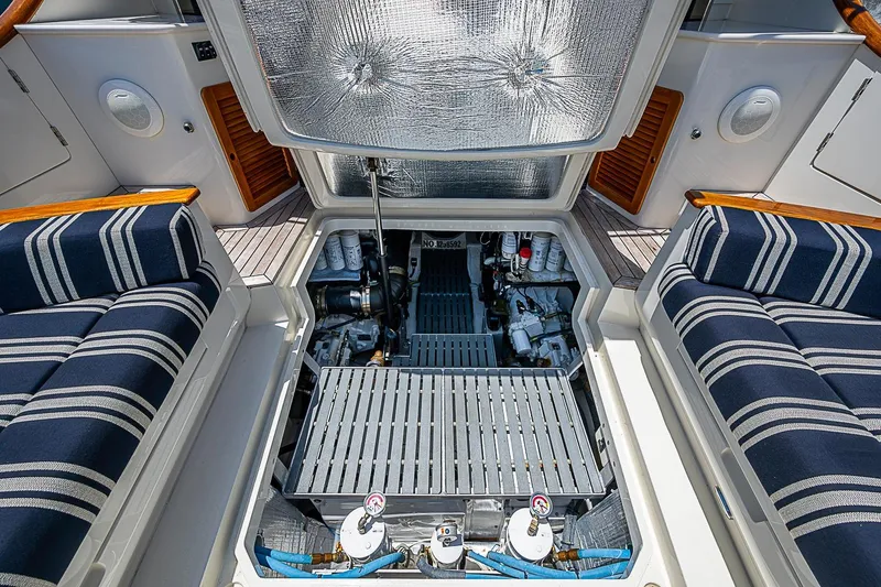 Slide: The Image of Engine compartment of 2015 Hinckley Talaria 48 yacht, featuring striped seating and wooden accents. - 32