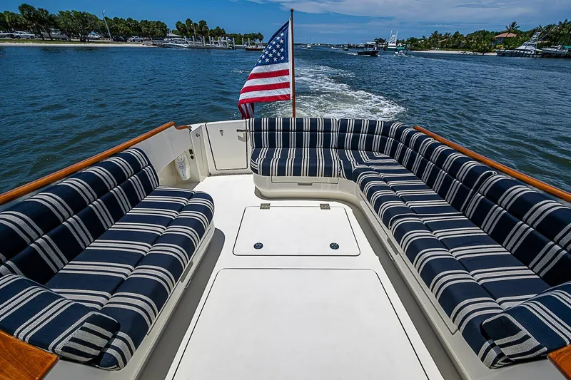 Slide: The Image of Hinckley Talaria 48 yacht deck with striped seating and American flag, cruising on a sunny day. - 5