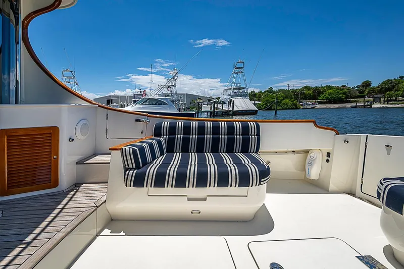 Slide: The Image of Hinckley Talaria 48 yacht deck with striped seating, docked by the water, 2015 model. - 6
