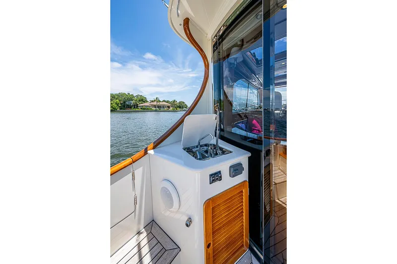 Slide: The Image of 2015 Hinckley Talaria 48 yacht deck with sink and scenic water view. - 9