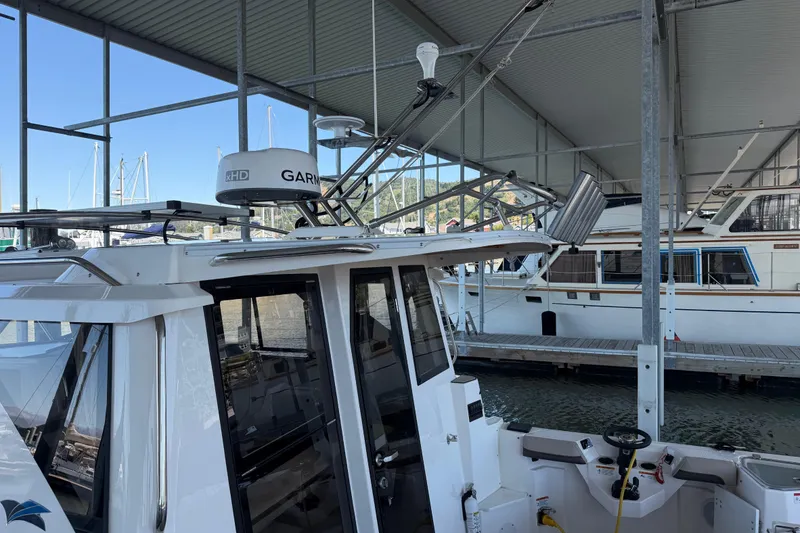 Slide: The Image of 2023 Cutwater C-288 Coupe docked under a covered marina with Garmin radar. - 13
