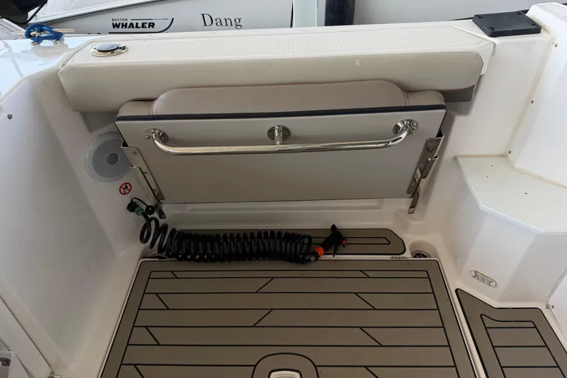 Slide: The Image of 2023 Cutwater C-288 Coupe boat deck with foldable seat and coiled hose. - 18