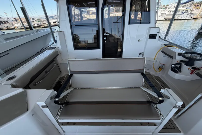 Slide: The Image of 2023 Cutwater C-288 Coupe cockpit with seating, steering wheel, and marina view. - 24