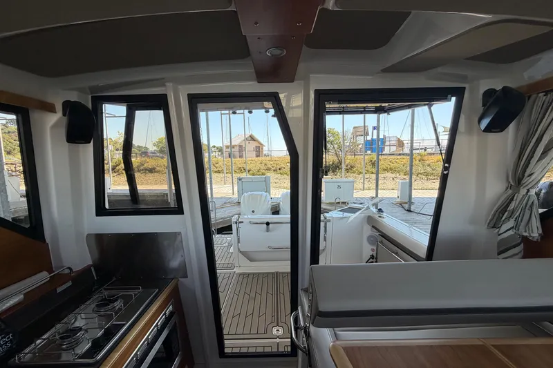 Slide: The Image of 2023 Cutwater C-288 Coupe interior with modern kitchen and outdoor view. - 28