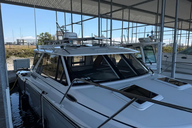 Slide: The Image of 2023 Cutwater C-288 Coupe docked under a covered marina, showcasing sleek design and modern features. - 3
