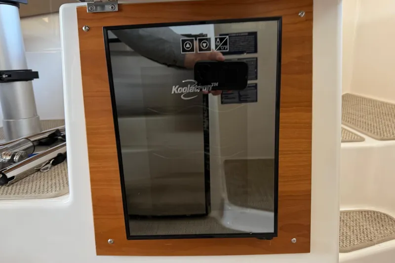 Slide: The Image of 2023 Cutwater C-288 Coupe interior with Koolatron fridge and wooden paneling. - 32