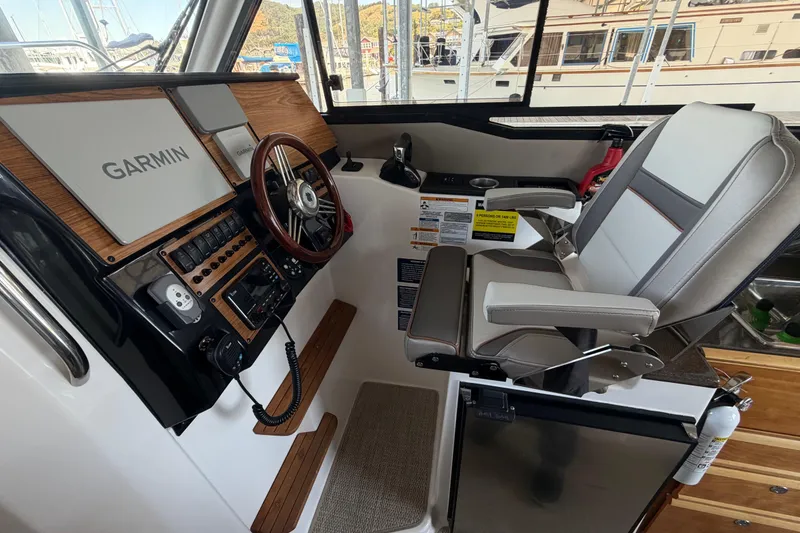 Slide: The Image of 2023 Cutwater C-288 Coupe helm with Garmin navigation, luxurious seating, and modern controls. - 33