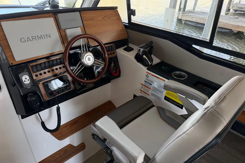 Slide: The Image of 2023 Cutwater C-288 Coupe helm with Garmin navigation, wood accents, and comfortable seating. - 34