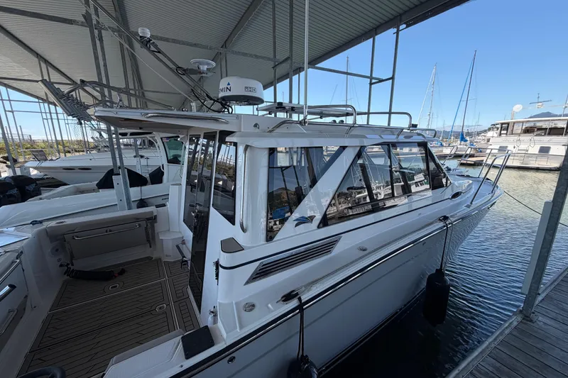 Slide: The Image of 2023 Cutwater C-288 Coupe docked in a marina under a covered structure. - 4
