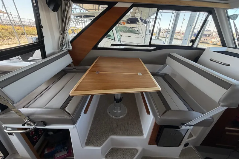 Slide: The Image of Interior of 2023 Cutwater C-288 Coupe featuring a stylish dining area with wood table. - 43