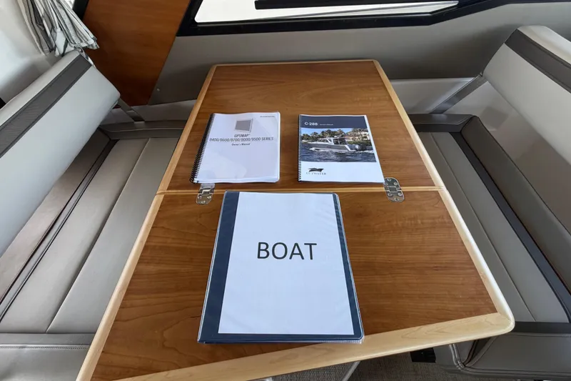 Slide: The Image of 2023 Cutwater C-288 Coupe interior with manuals on a wooden table. - 44