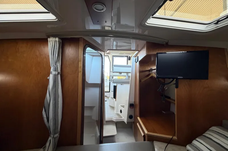 Slide: The Image of Interior of 2023 Cutwater C-288 Coupe boat with wood finish and mounted TV. - 49
