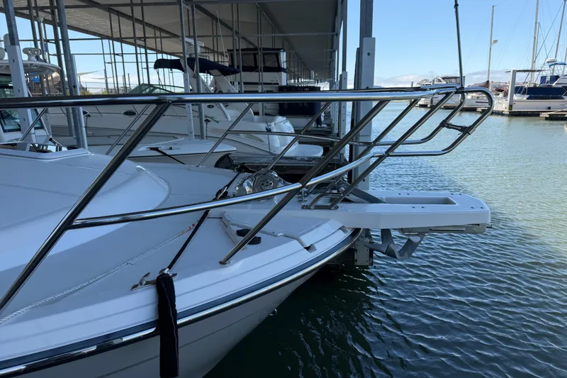 Slide: The Image of 2023 Cutwater C-288 Coupe boat docked, showcasing sleek bow design and stainless steel railings. - 5