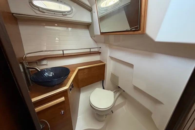 Slide: The Image of 2023 Cutwater C-288 Coupe bathroom with modern sink, toilet, and wooden cabinetry. - 51