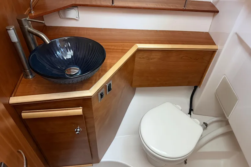 Slide: The Image of 2023 Cutwater C-288 Coupe bathroom with wooden cabinetry and modern glass sink. - 52