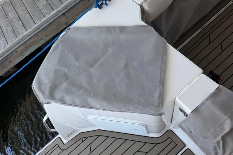 Slide: The Image of 2023 Cutwater C-288 Coupe boat deck with protective cover, docked by wooden pier. - 56