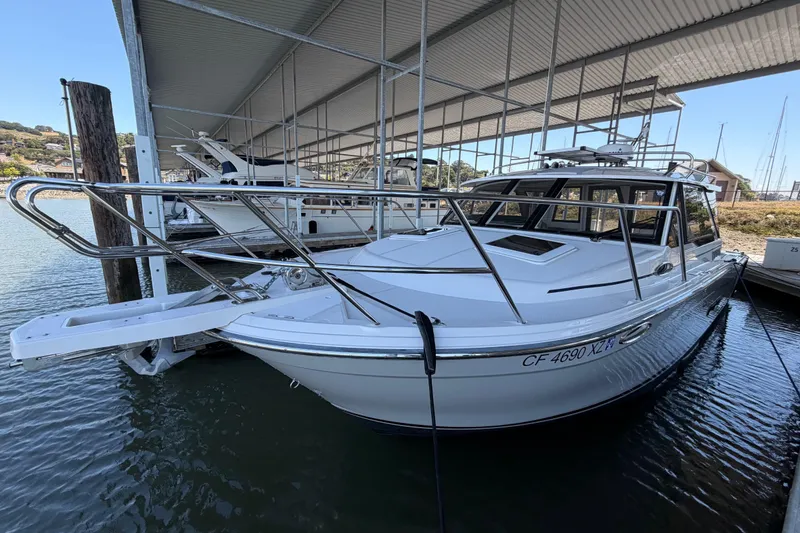 Slide: The Image of 2023 Cutwater C-288 Coupe docked under a covered marina, showcasing sleek design and modern features. - 7
