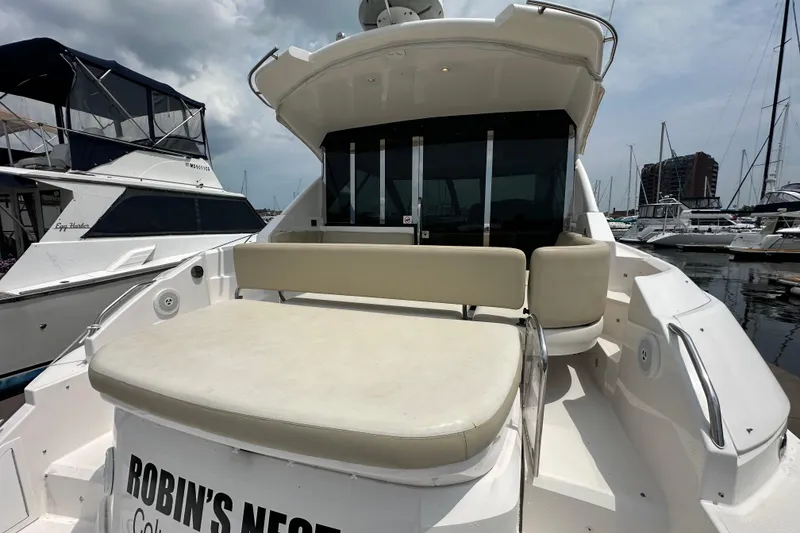 Slide: The Image of 2012 Regal 42 Sport Coupe yacht docked at marina, featuring spacious seating area. - 11