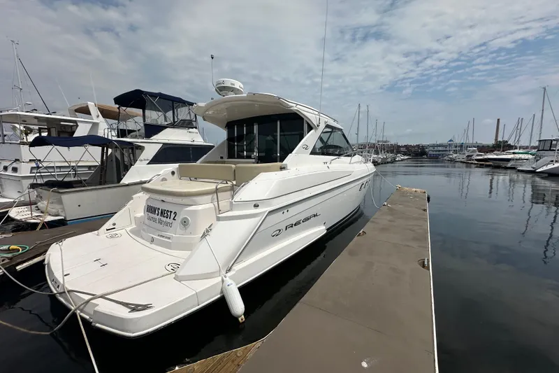 Slide: The Image of 2012 Regal 42 Sport Coupe yacht docked at marina under cloudy sky. - 2