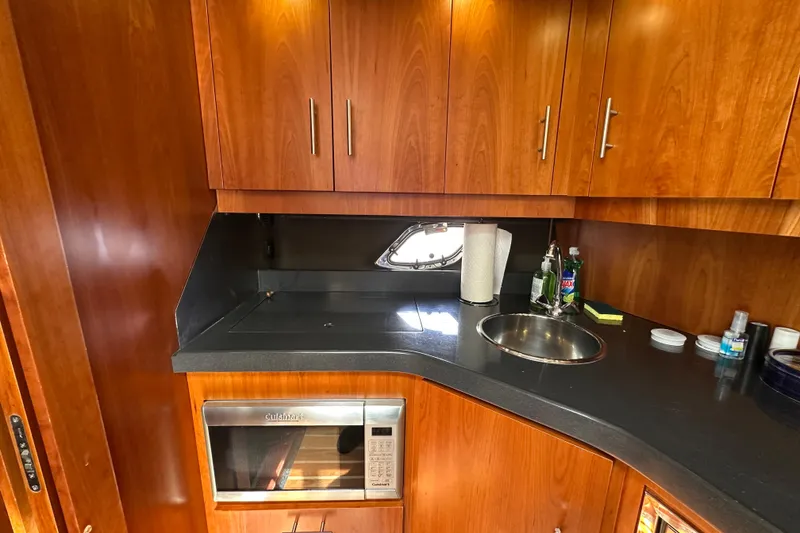 Slide: The Image of 2012 Regal 42 Sport Coupe yacht kitchen with wood cabinets and modern appliances. - 26