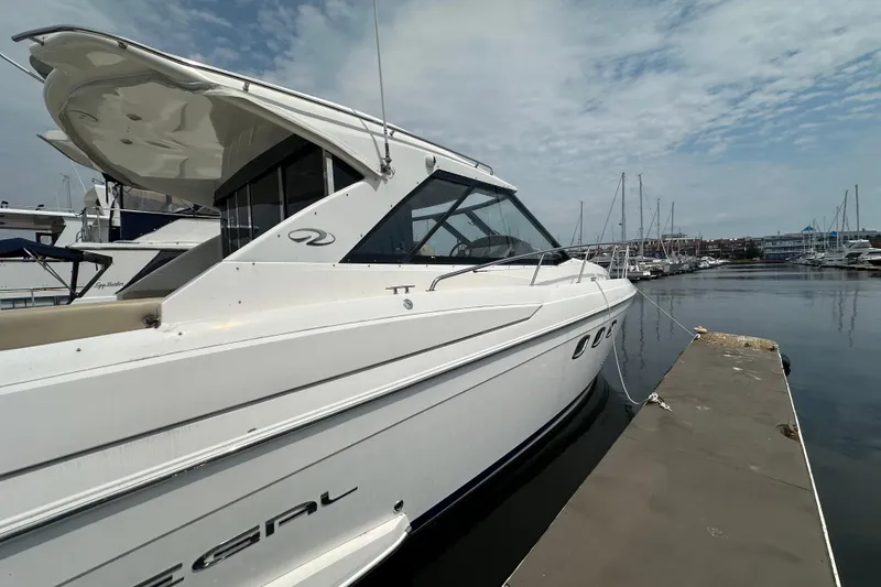 Slide: The Image of 2012 Regal 42 Sport Coupe yacht docked at marina under cloudy sky. - 3