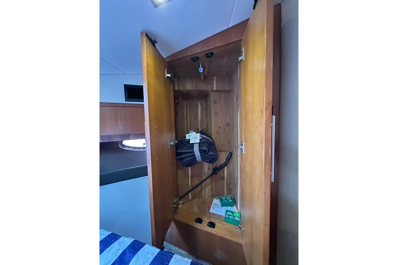 Slide: The Image of Open wooden closet inside 2012 Regal 42 Sport Coupe yacht cabin. - 33