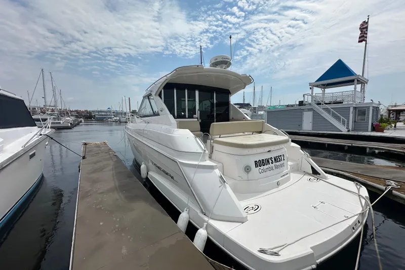 Slide: The Image of 2012 Regal 42 Sport Coupe yacht docked at marina, clear sky, calm water. - 4