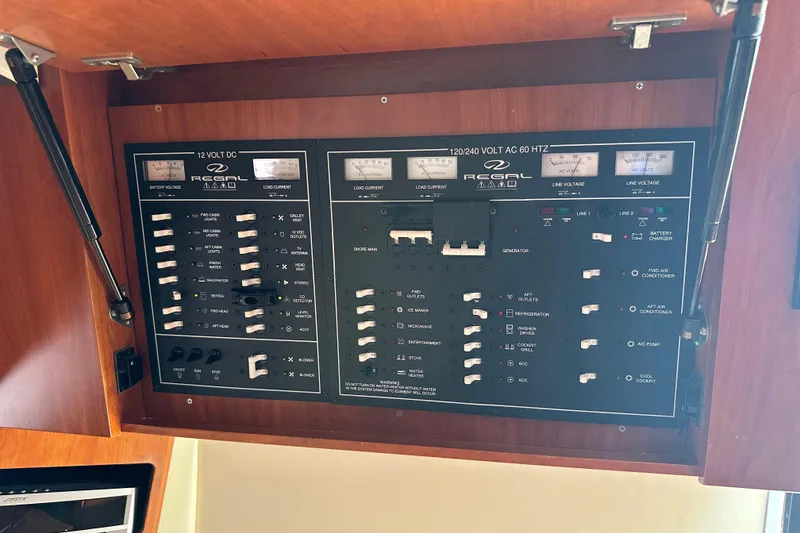 Slide: The Image of Electrical control panel of a 2012 Regal 42 Sport Coupe boat, featuring various switches and gauges. - 40