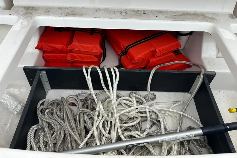 Slide: The Image of Storage compartment on a 2012 Regal 42 Sport Coupe with ropes and red life jackets. - 47