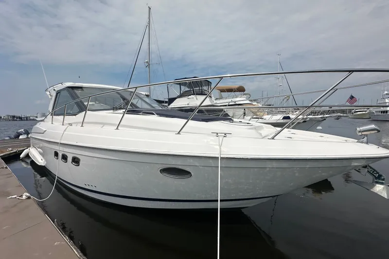 Slide: The Image of 2012 Regal 42 Sport Coupe yacht docked at marina under cloudy sky. - 6