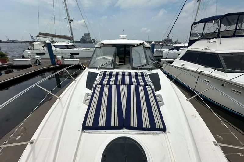 Slide: The Image of 2012 Regal 42 Sport Coupe yacht docked at marina with striped sun pads. - 7