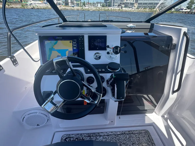 Slide: The Image of The cockpit of an Axopar 25 Cross Top boat with steering wheel and navigation system. - 17