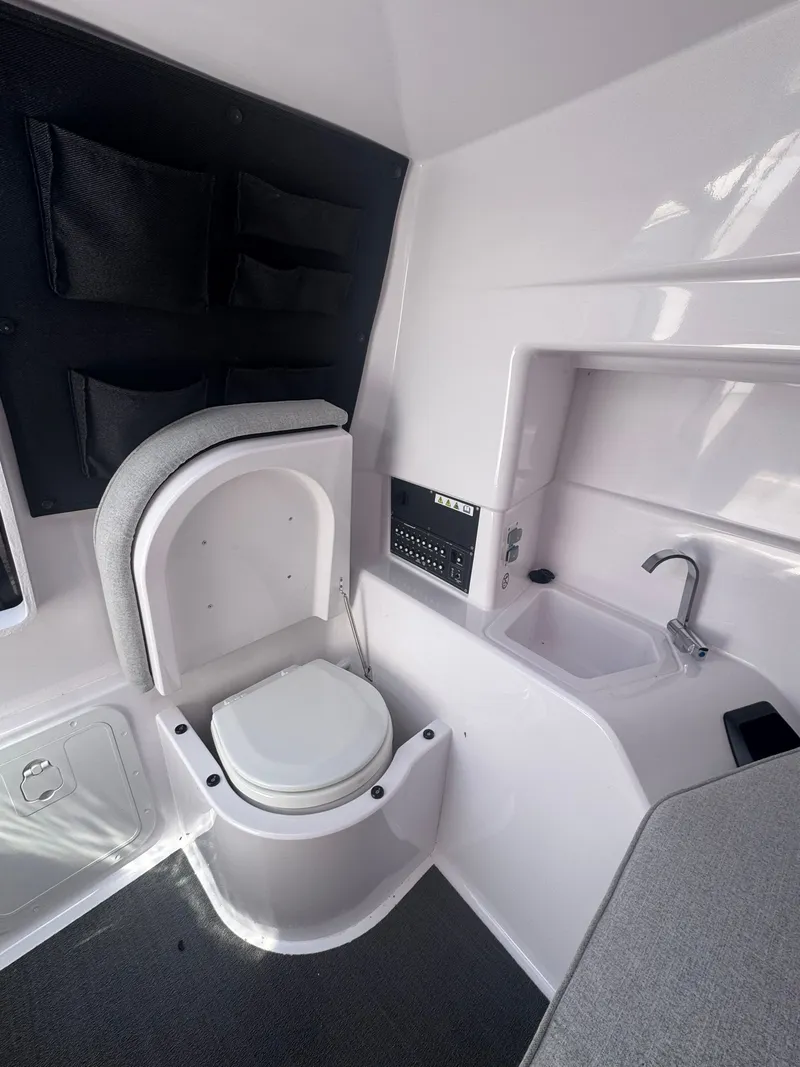 Slide: The Image of Interior of a boat with a toilet, sink, and storage space. - 24