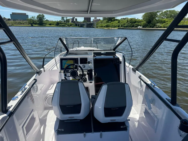 Slide: The Image of The cockpit of a modern boat with two seats and a helm on a river. - 3