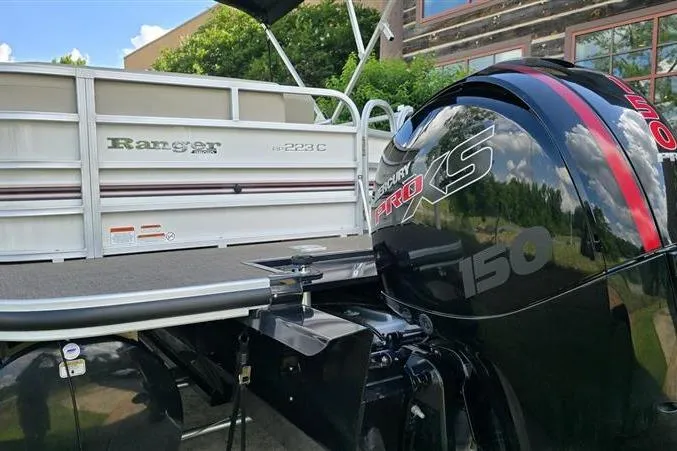 Slide: The Image of 2023 Ranger Reata 223C pontoon boat with Mercury Pro XS 150 engine, docked outdoors. - 3