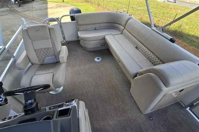 Slide: The Image of 2023 Ranger Reata 223C pontoon boat interior with plush seating and steering console. - 5
